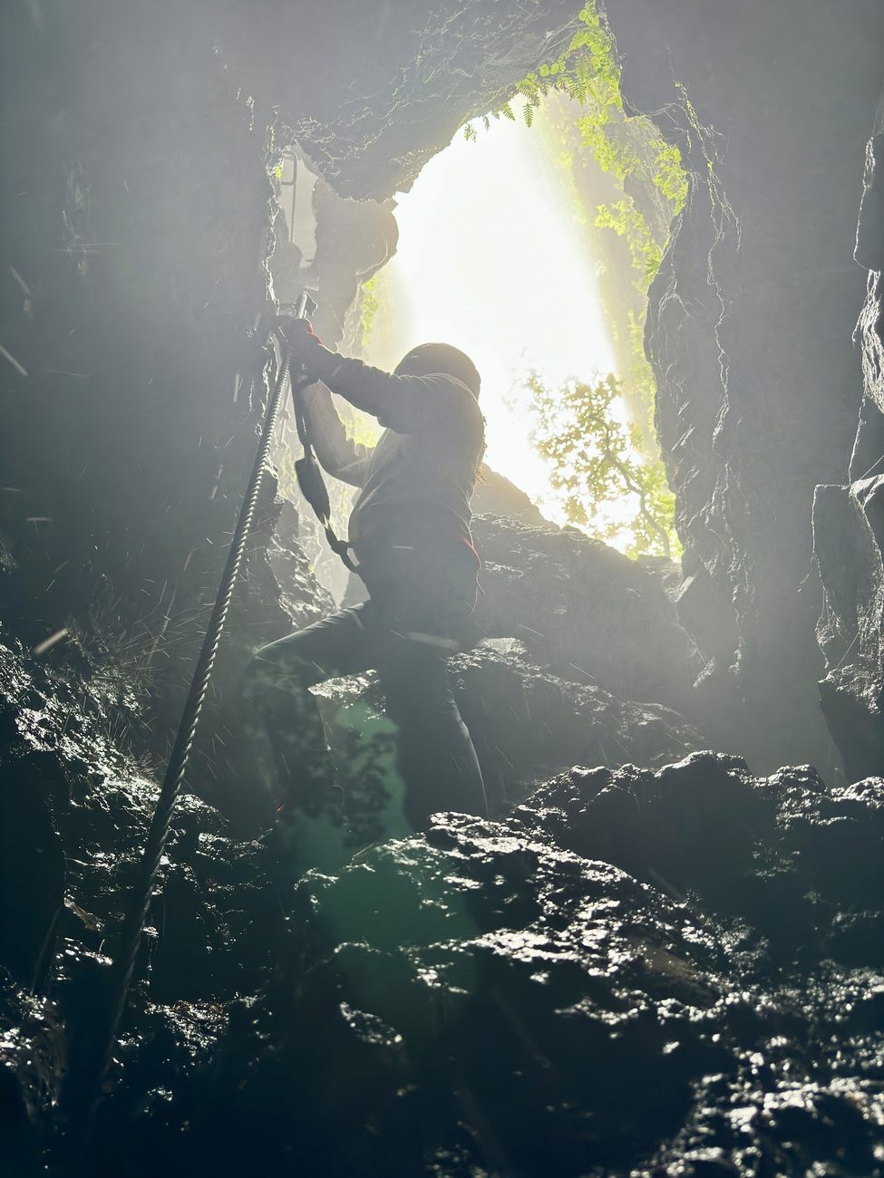 Via ferrata egy barlangszerű szurdokban, ellenfényben